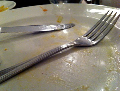 A fork and knife on an empty plate